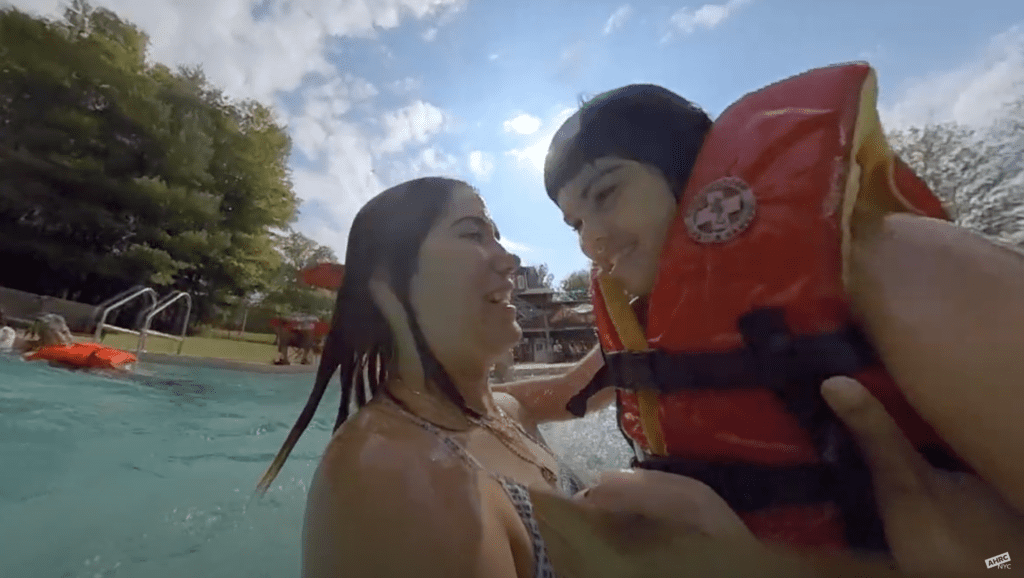 Clementine swimming with her counselor at summer camp